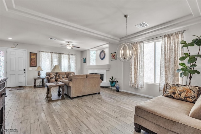 6461 Mount Eden Ave, Las Vegas, NV 89139 - living area with light wood-style flooring, baseboards, a glass covered fireplace, visible vents, and a raised ceiling
