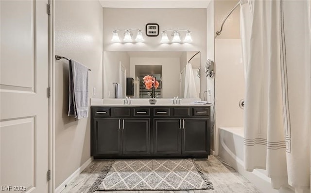 full bathroom with shower / tub combo with curtain, wood finished floors, a sink, and double vanity