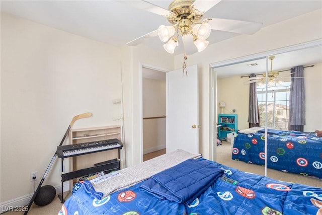 carpeted bedroom with ceiling fan and a closet