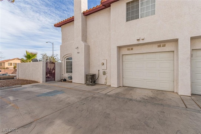 view of side of home with a garage and cooling unit