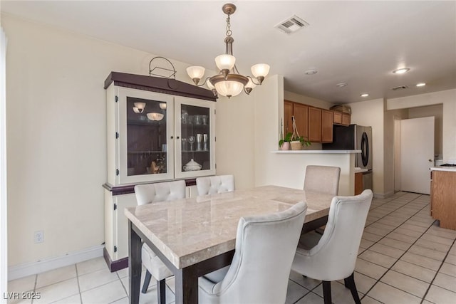 dining area with light tile patterned floors and a notable chandelier