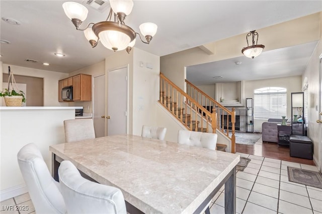 dining room featuring an inviting chandelier and light tile patterned floors