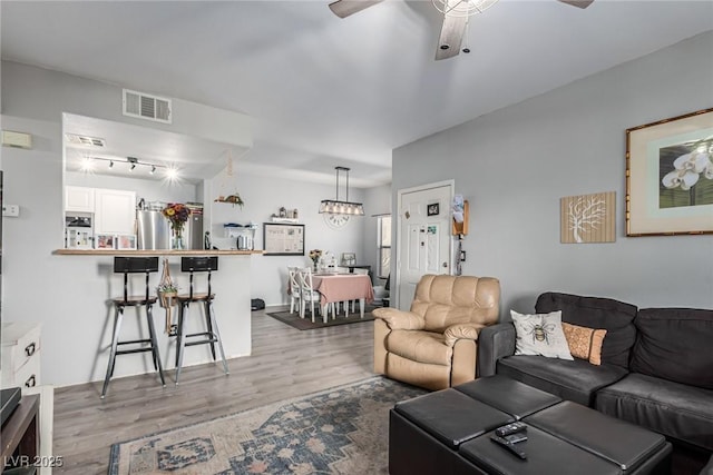 living room featuring ceiling fan and light hardwood / wood-style flooring