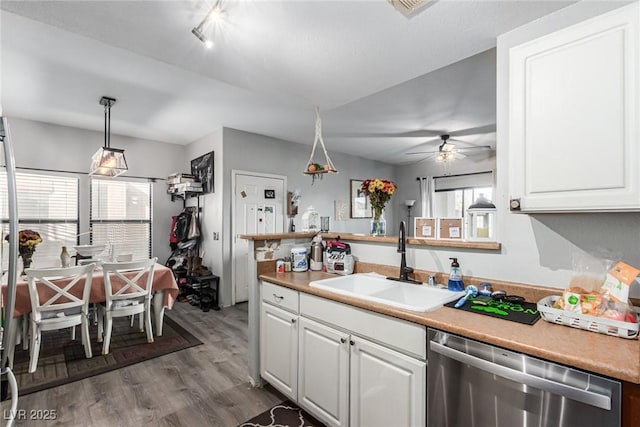 kitchen with pendant lighting, sink, dark wood-type flooring, white cabinetry, and stainless steel dishwasher