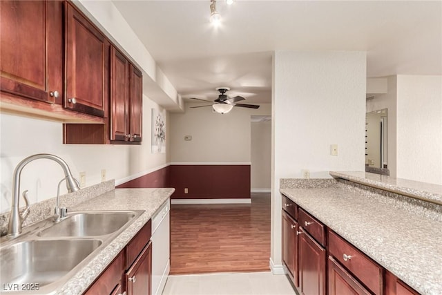 kitchen with ceiling fan, sink, light stone counters, and white dishwasher