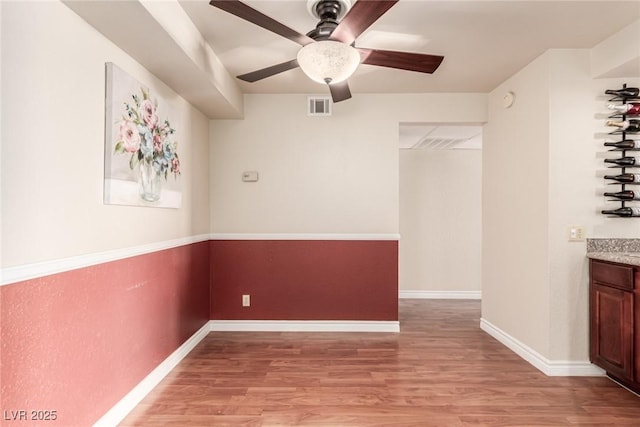 unfurnished room with ceiling fan and light wood-type flooring