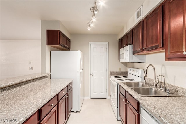 kitchen with sink, track lighting, and white appliances