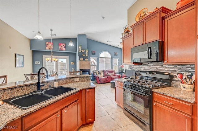 kitchen featuring sink, light stone counters, black appliances, light tile patterned flooring, and decorative light fixtures