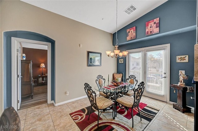 dining space featuring a chandelier, vaulted ceiling, and light tile patterned floors