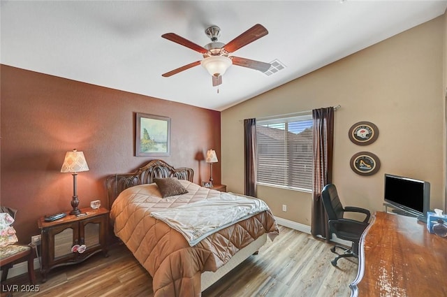 bedroom with ceiling fan, lofted ceiling, and hardwood / wood-style floors