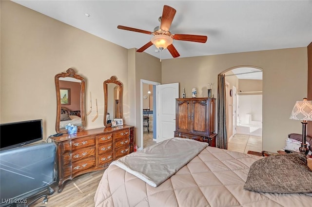 bedroom with light hardwood / wood-style flooring, ceiling fan, and ensuite bath