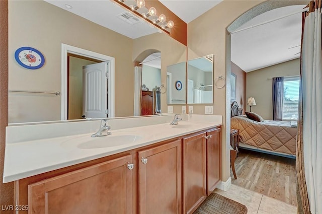 bathroom featuring tile patterned floors, vanity, and lofted ceiling