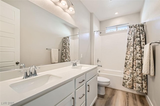 full bathroom with wood-type flooring, toilet, shower / bath combo with shower curtain, and vanity