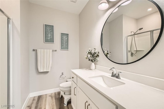 bathroom with vanity, toilet, hardwood / wood-style floors, and walk in shower