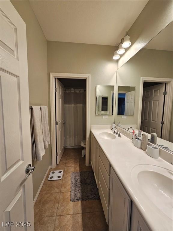 bathroom with tile patterned flooring, vanity, and toilet