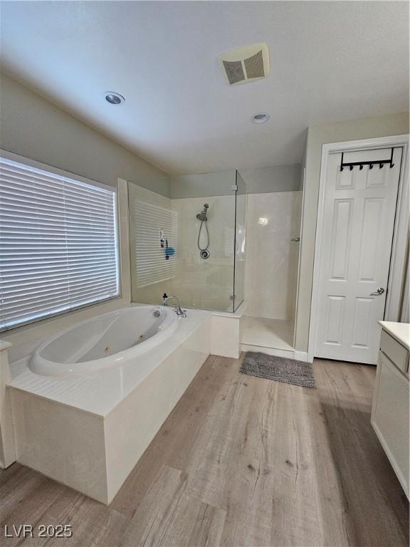 bathroom featuring shower with separate bathtub, wood-type flooring, and vanity