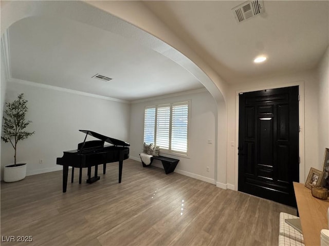 entrance foyer featuring wood-type flooring and ornamental molding