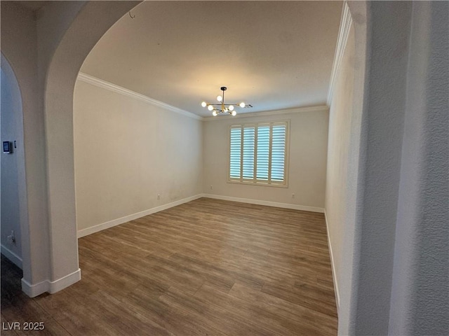 unfurnished room with dark hardwood / wood-style flooring, a notable chandelier, and ornamental molding