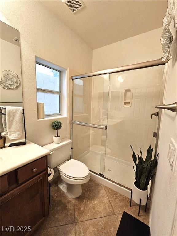 bathroom featuring an enclosed shower, vanity, tile patterned floors, and toilet