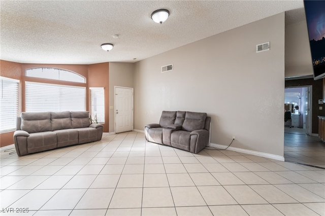 tiled living room with a healthy amount of sunlight, vaulted ceiling, and a textured ceiling