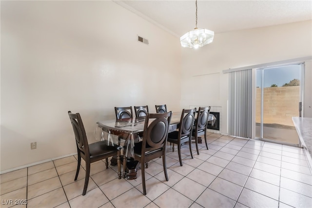 dining area featuring a high ceiling, light tile patterned floors, and a notable chandelier