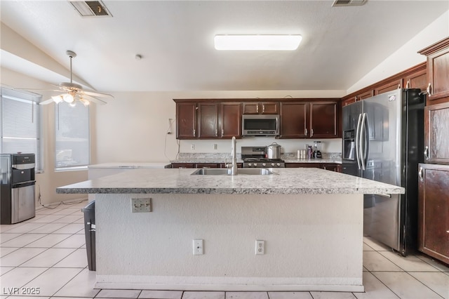 kitchen featuring vaulted ceiling, stainless steel appliances, and an island with sink