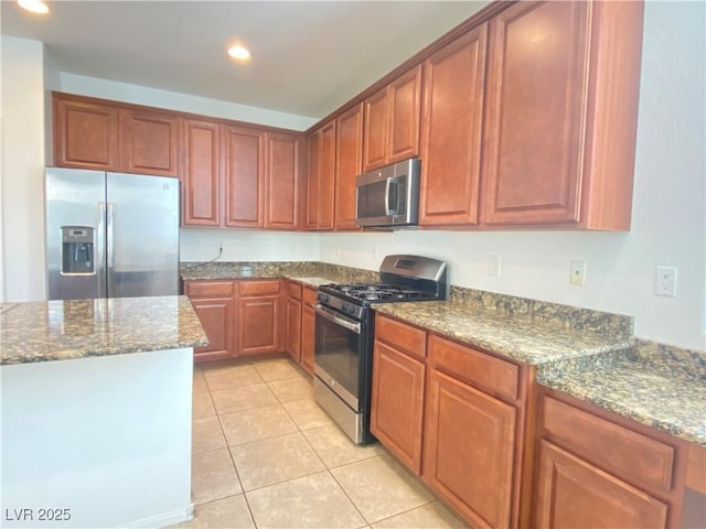 kitchen featuring light tile patterned floors, stainless steel appliances, and stone counters