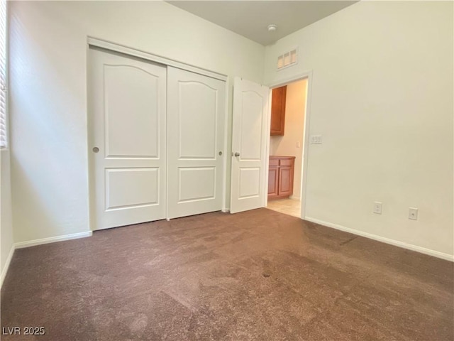 unfurnished bedroom with a closet and carpet