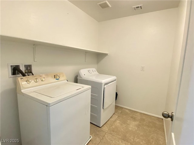 clothes washing area featuring light tile patterned flooring and washer and clothes dryer