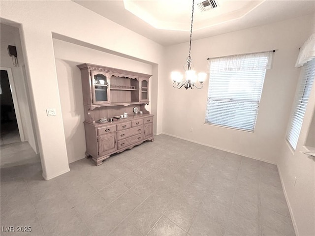 dining room with a notable chandelier and a tray ceiling