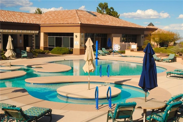 view of swimming pool featuring a community hot tub and a patio