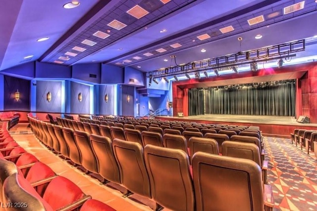 home theater room with beamed ceiling and carpet floors