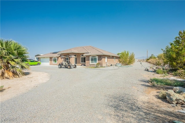 view of front of property featuring a garage and solar panels