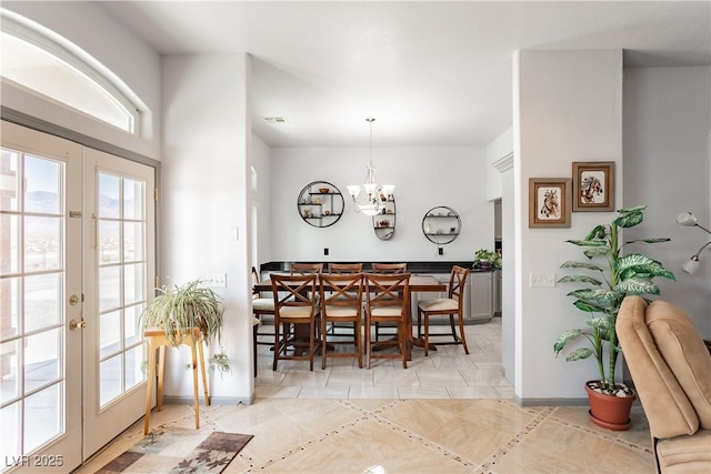 dining space featuring a notable chandelier and french doors