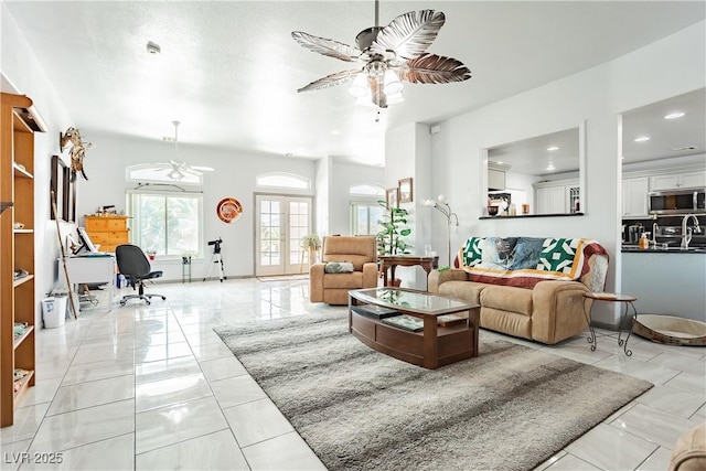 living room with sink, french doors, and ceiling fan