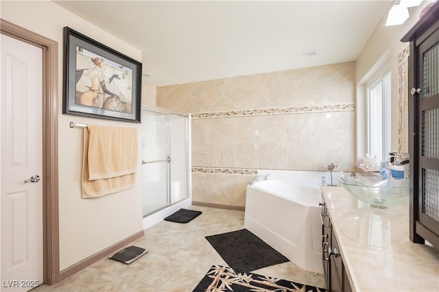 bathroom with tile walls, vanity, and independent shower and bath