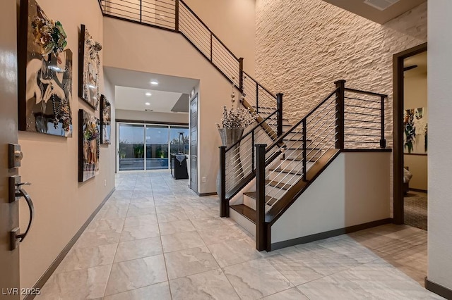 stairway featuring a towering ceiling