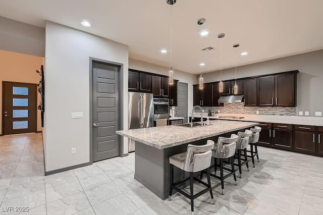 kitchen with sink, hanging light fixtures, an island with sink, and appliances with stainless steel finishes