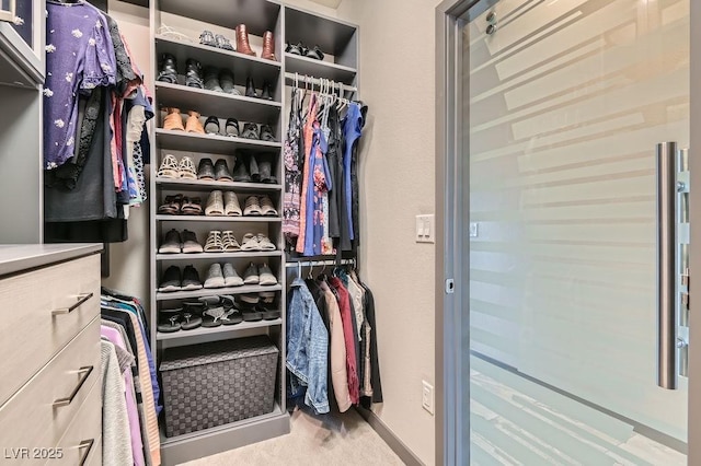 walk in closet with carpet flooring