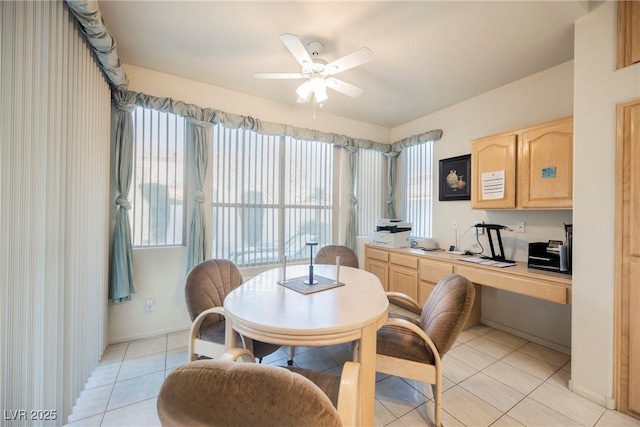 dining area with light tile patterned floors, built in desk, and ceiling fan