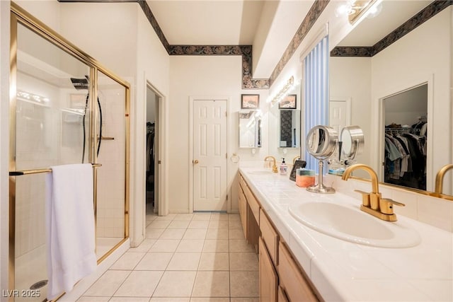 bathroom with vanity, crown molding, tile patterned floors, and tiled shower