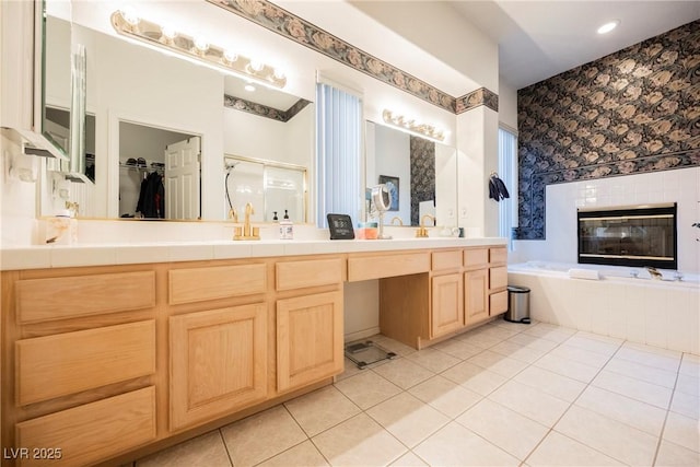 bathroom featuring tile patterned flooring, vanity, separate shower and tub, and a fireplace