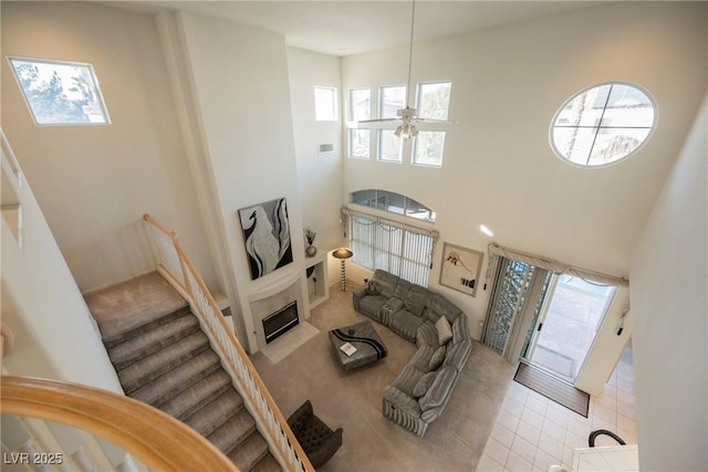 living room with ceiling fan and a high ceiling