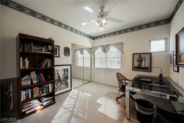 carpeted office featuring ceiling fan