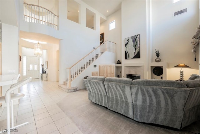 living room featuring a notable chandelier, a high ceiling, and light tile patterned flooring