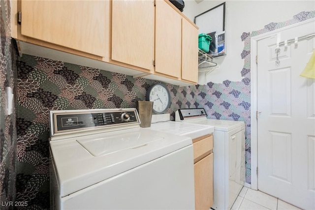 washroom with washer and dryer, light tile patterned floors, and cabinets