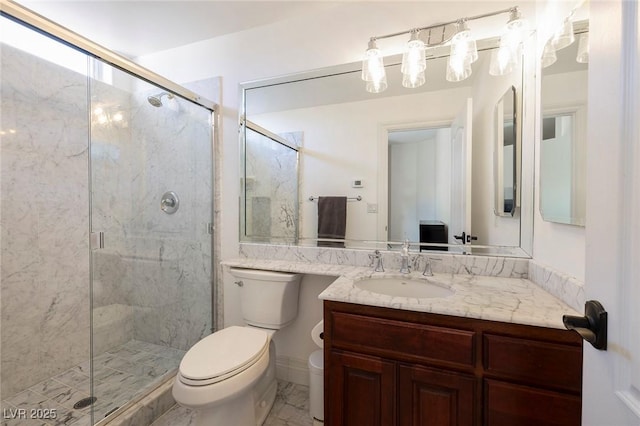 bathroom featuring vanity, a shower with door, and toilet