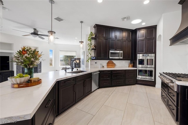 kitchen with premium range hood, sink, decorative light fixtures, stainless steel appliances, and decorative backsplash