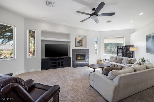 carpeted living room with built in shelves, a fireplace, and ceiling fan