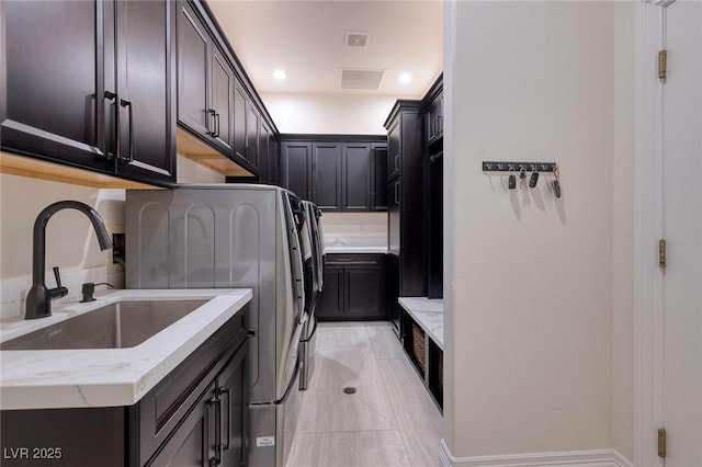 laundry area featuring washer and dryer, sink, light tile patterned floors, and cabinets